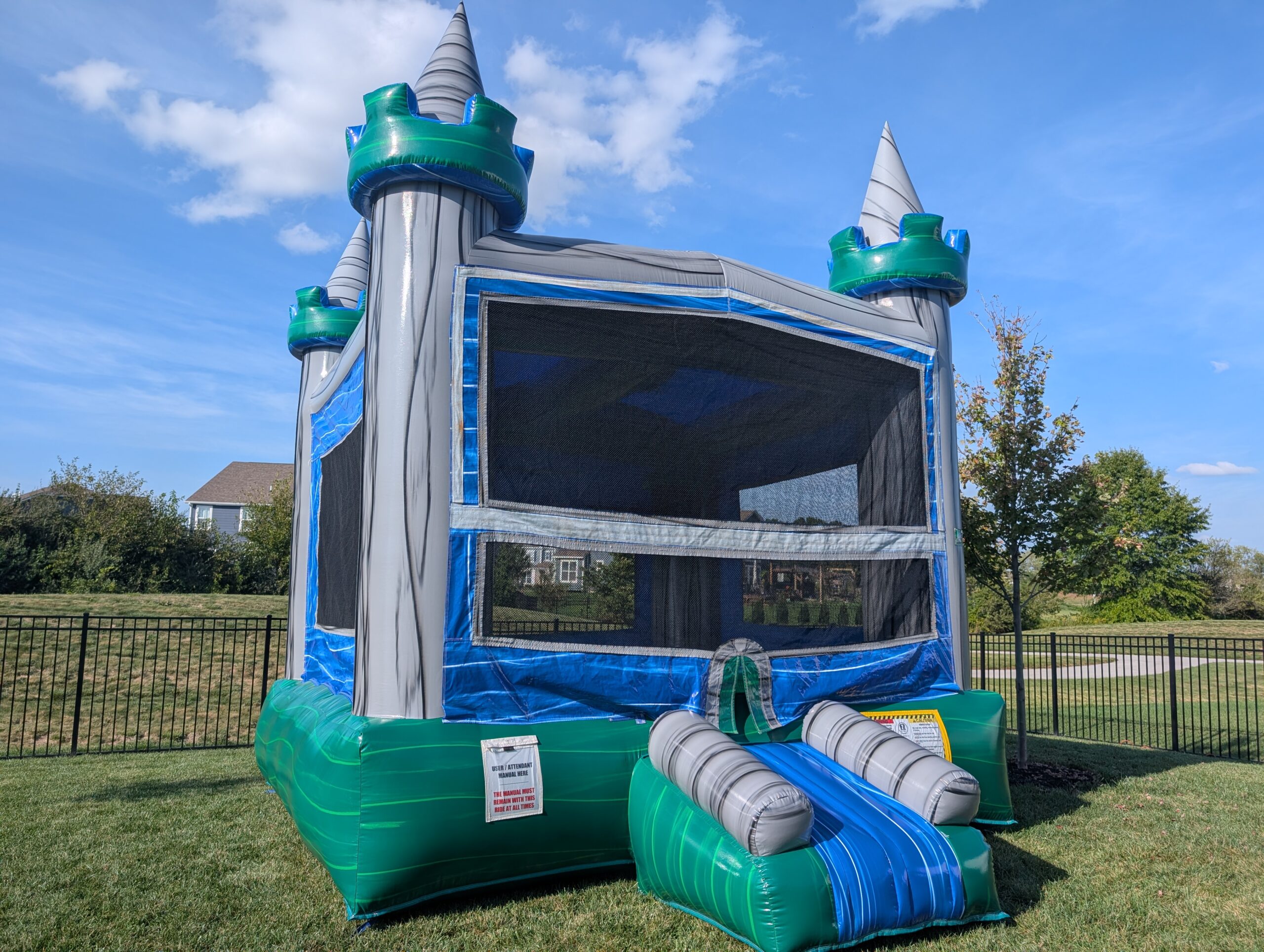 Blue and green castle bounce house on a lawn at a Bargersville home