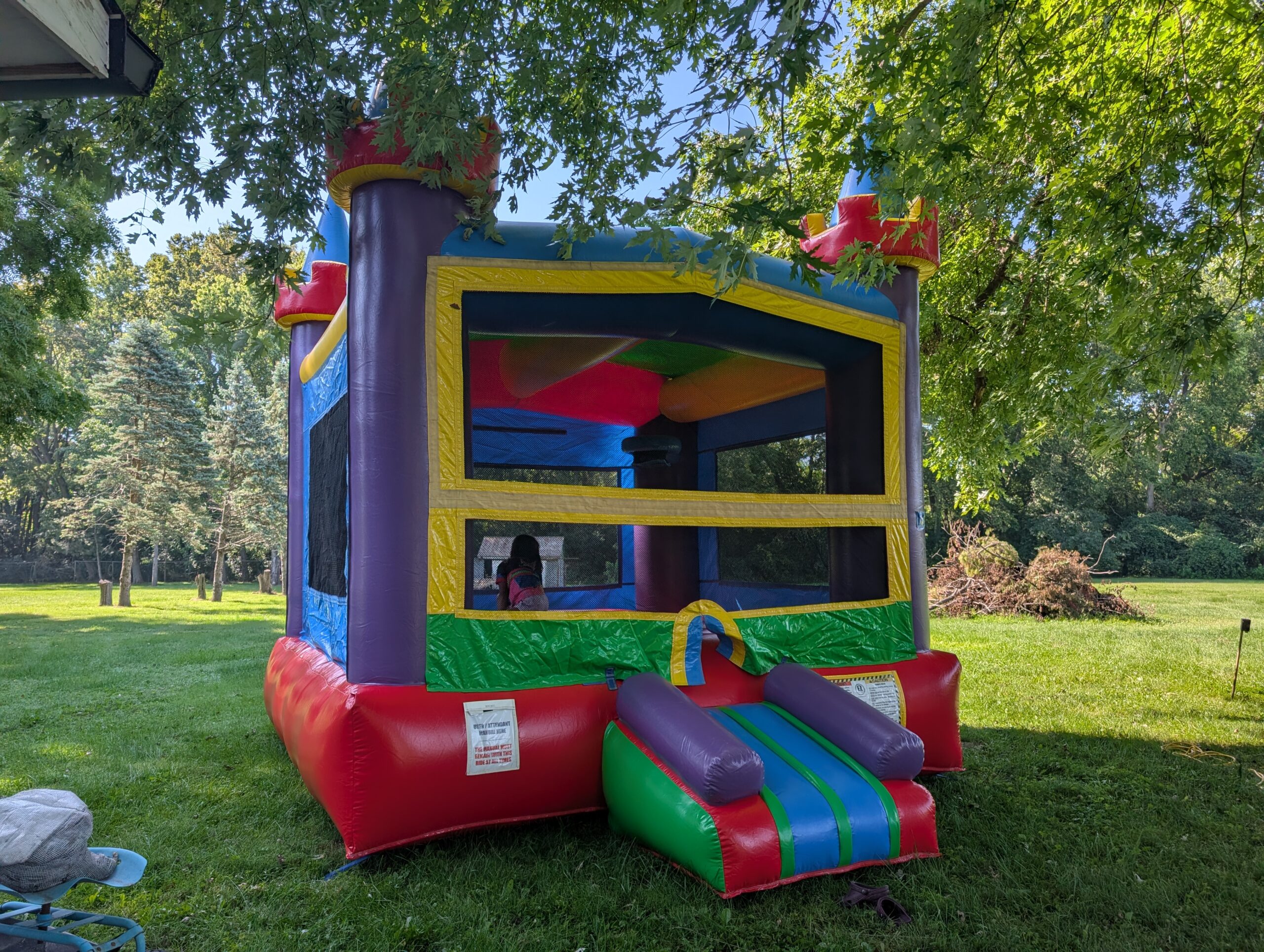 Colorful bounce house beneath trees in Indianapolis