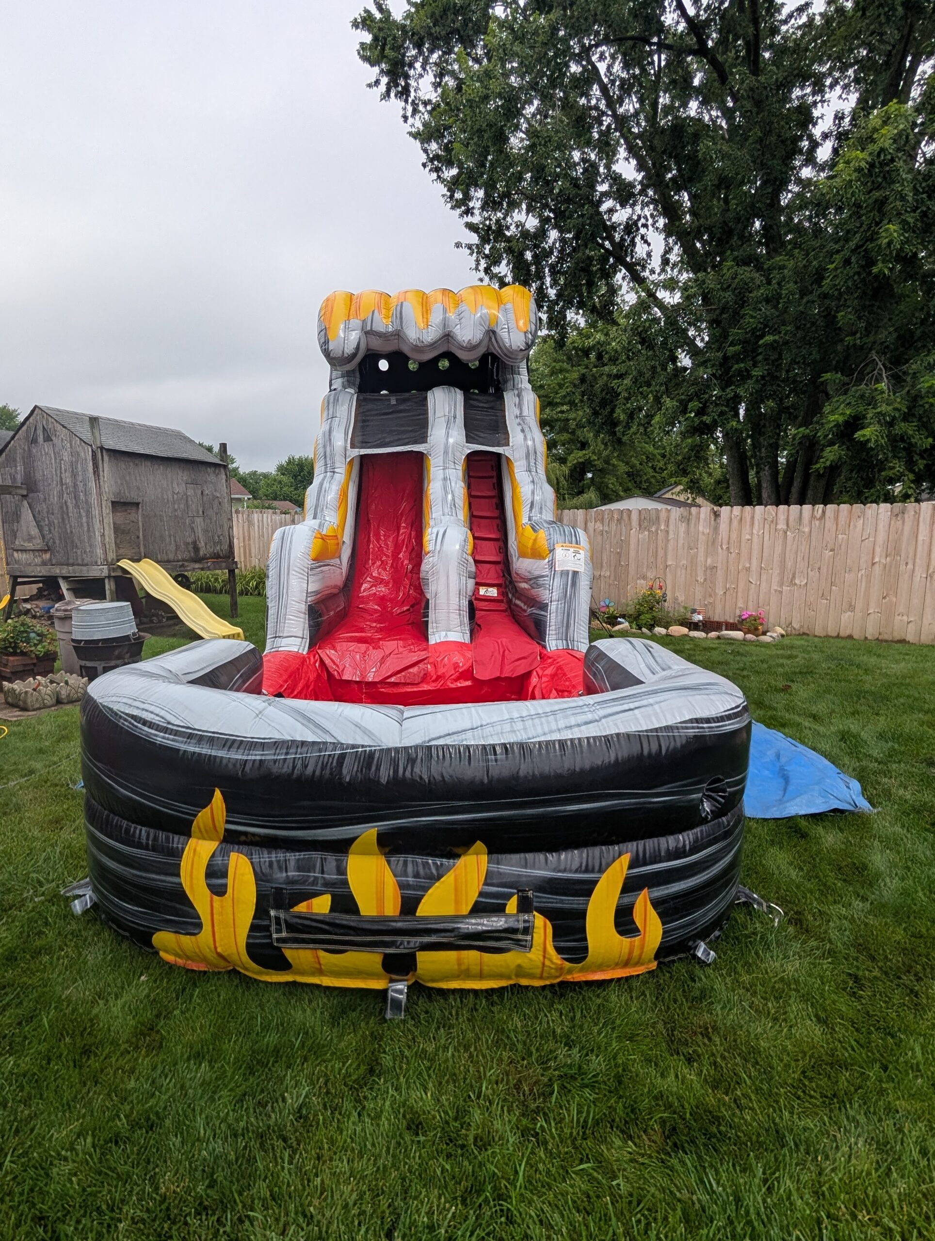 Gray, yellow and red waterslide in a fenced Whiteland backyard